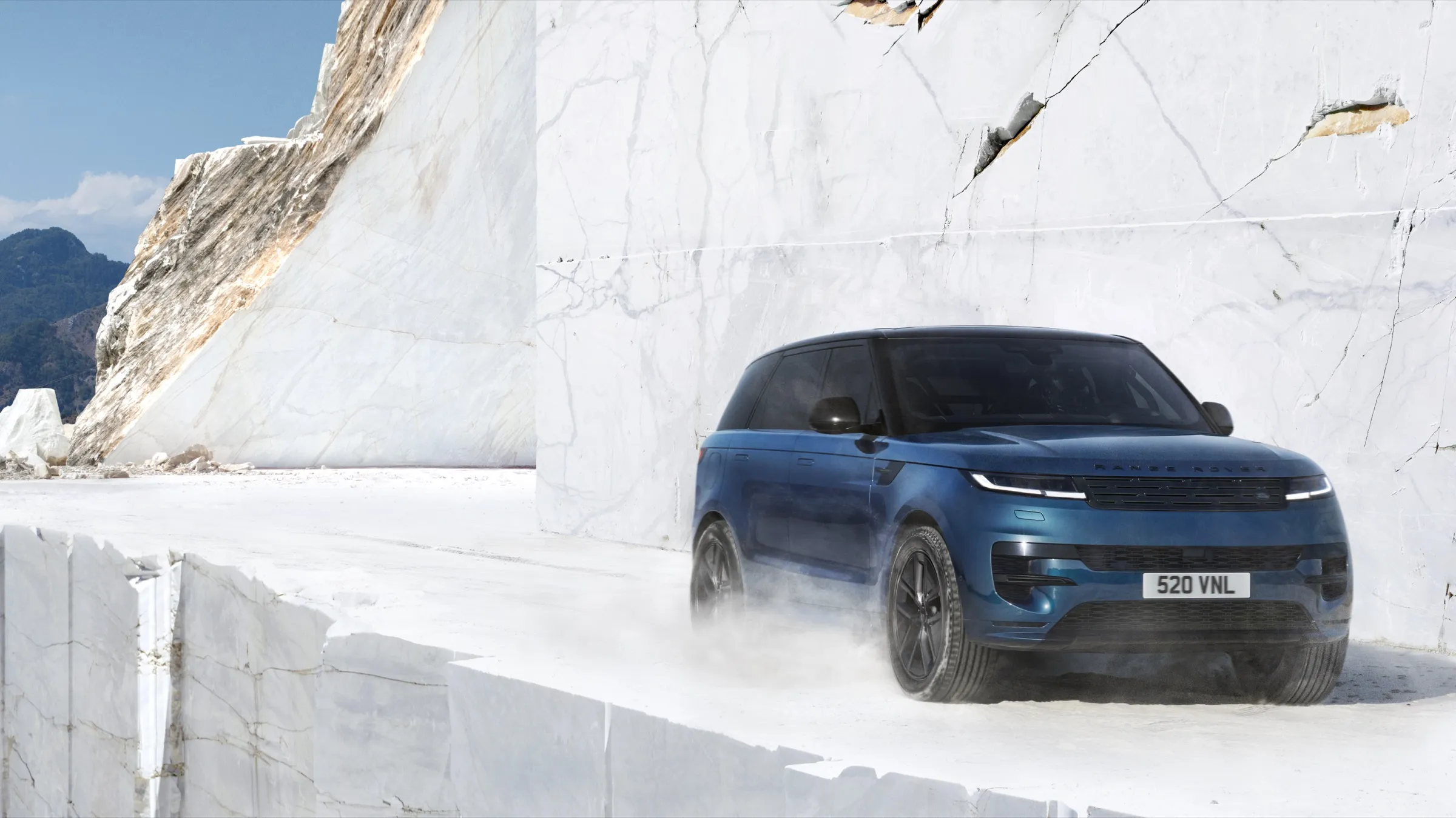 Blue Range Rover Sport Electric, front three-quarter view, on white marble