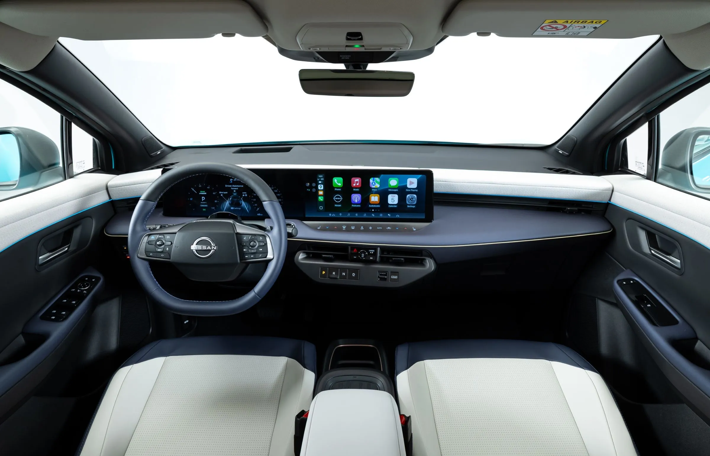 Nissan Leaf cabin from the rear seats, showing the dashboard and light interior