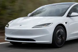 White Tesla Model 3 driving, front three-quarter view